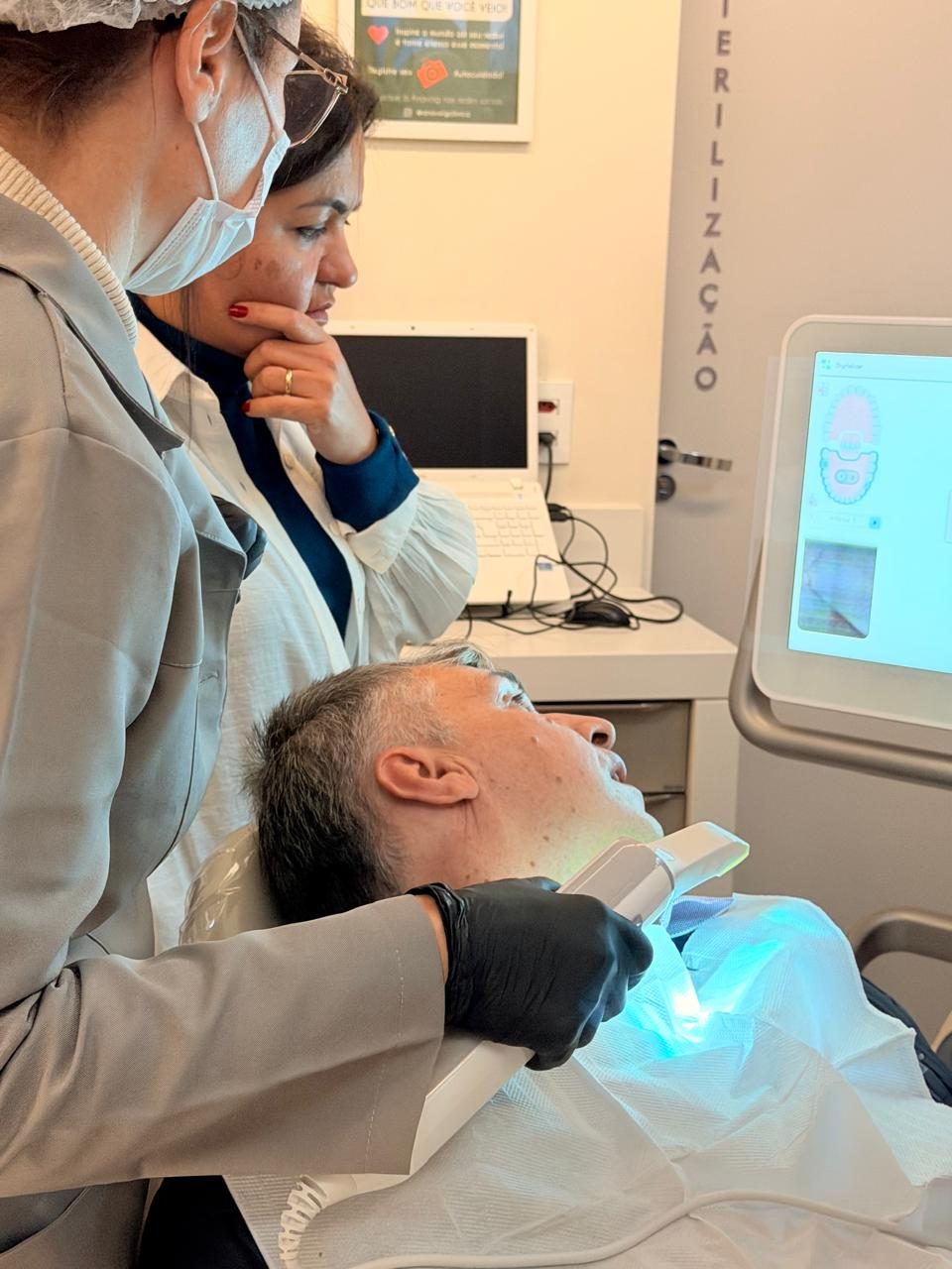 Atendimento odontológico com equipamento digital em consultório